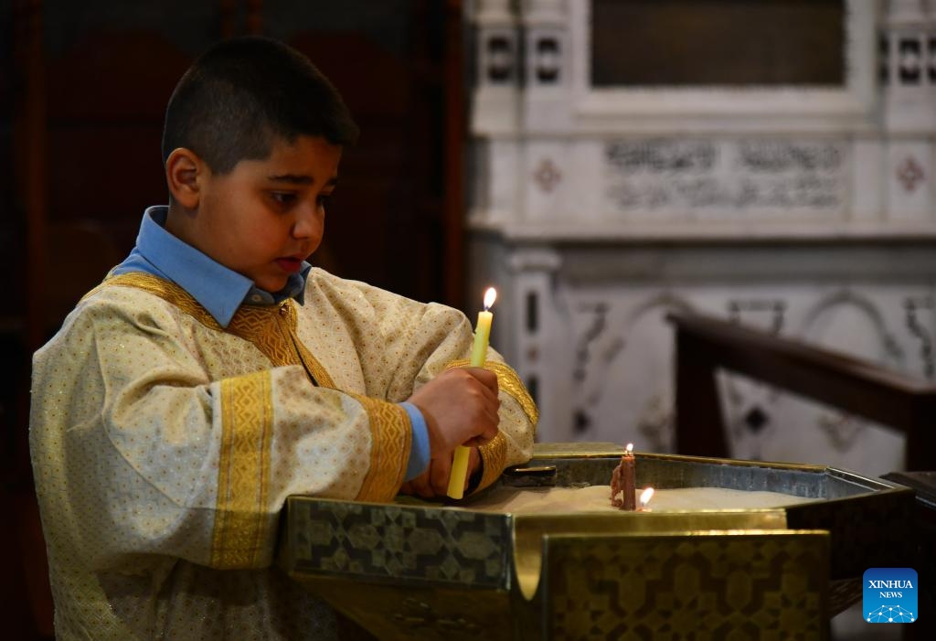 A worshipper lights candles during Palm Sunday services at a church in Damascus, Syria, on March 29, 2026. Palm Sunday is a Christian feast that falls on the Sunday before Easter and marks the beginning of the Holy Week. (Photo by Ammar Safarjalani/Xinhua)