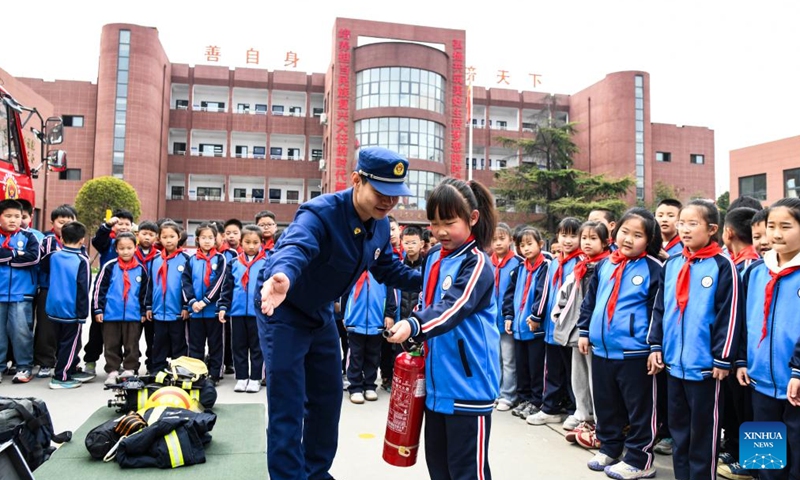 A pupil learns how to use fire extinguisher at a primary school in Jiyuan City, central China's Henan Province, March 30, 2026. March 30 marks China's national safety education day for middle and primary school students. (Photo by Miao Qiunao/Xinhua)