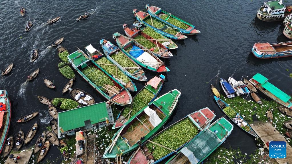 A drone photo taken on March 30, 2026 shows workers unloading watermelons from boats at Sadarghat along the Buriganga River in Dhaka, Bangladesh. (Photo by Habibur Rahman/Xinhua)

