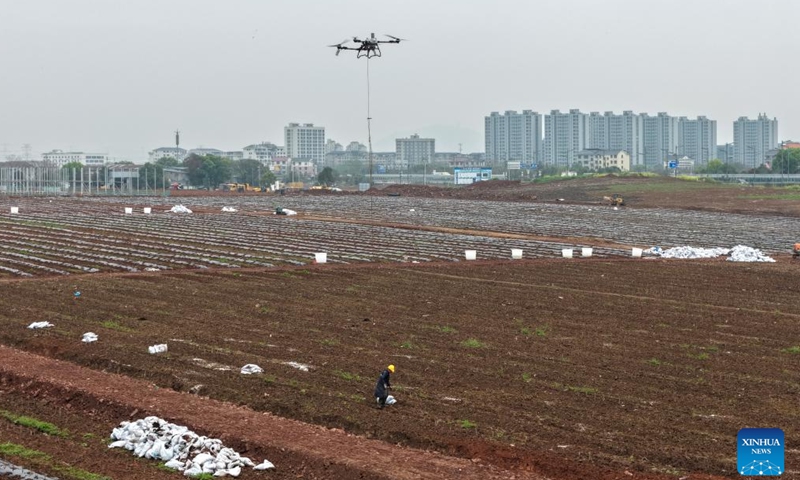 A drone photo taken on March 27, 2026 shows a drone helping a farmer deliver bags of fertilizer in the fields in Jindong District of Jinhua City, east China's Zhejiang Province. (Photo by Shi Kuanbing/Xinhua)

