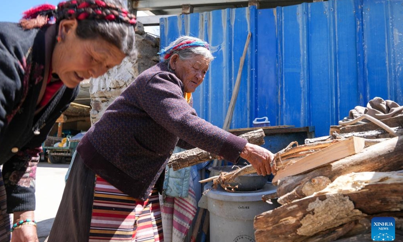 Tsering Sangmo (L) and her daughter arrange lumber at her home in Zongkhar Village of Shannan City, southwest China's Xizang Autonomous Region, March 26, 2026. (Xinhua/Jigme Dorje)