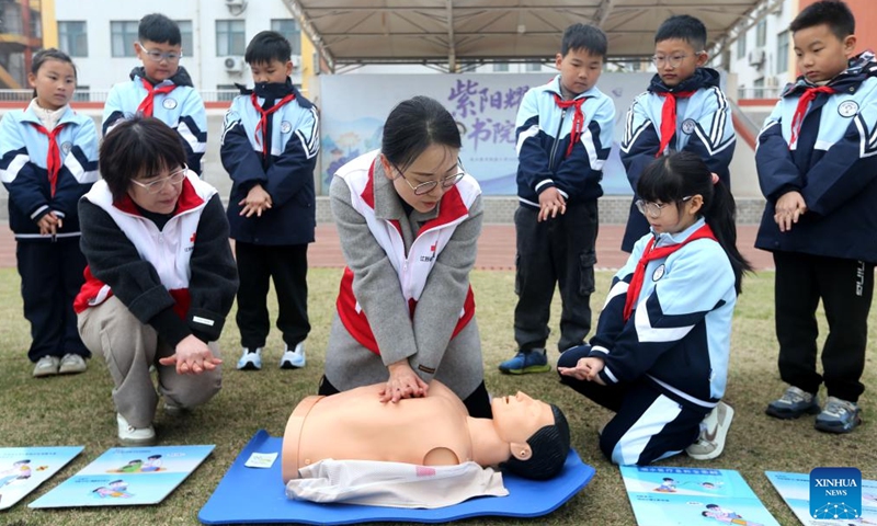 A volunteer introduces emergency rescue knowledge to pupils at a primary school in Lianyungang City, east China's Jiangsu Province, March 30, 2026. March 30 marks China's national safety education day for middle and primary school students. (Photo by Wang Chun/Xinhua)