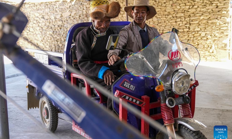 Padma Tashi (L) sits on a new electric tricycle bought by his son-in-law at home in Zhanang County, southwest China's Xizang Autonomous Region, March 26, 2026. (Xinhua/Jigme Dorje)