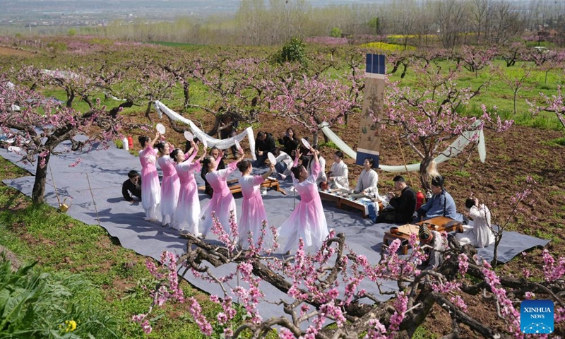 A cultural event is held amid peach blossom in Chang'an District of Xi'an, northwest China's Shaanxi Province, March 31, 2026. Cultural events were held among peach blossom at the foot of Zhongnan Mountains in Chang'an District of Xi'an, attracting tourists to visit. (Xinhua/Shao Rui)

