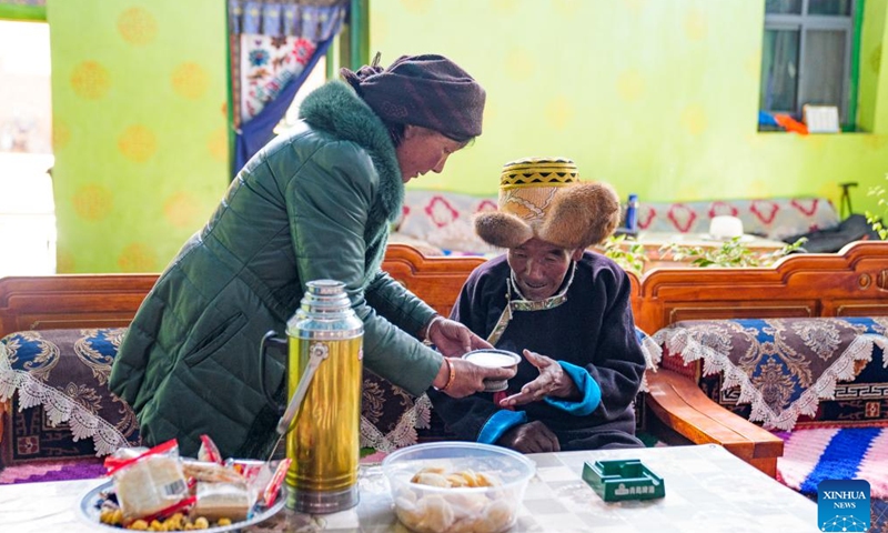 Padma Tashi (R) gets a bowl of butter tea at home in Zhanang County, southwest China's Xizang Autonomous Region, March 26, 2026. (Xinhua/Tenzin Nyida)