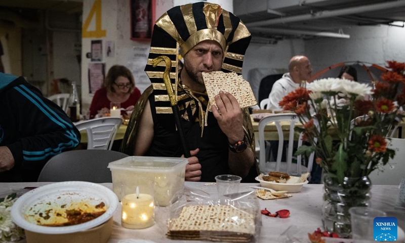 A man eats Matzo, or unleavened bread, during a Passover Seder at an underground shelter in Tel Aviv, Israel, April 1, 2026. The week-long Jewish holiday of Passover began at sunset on April 1 and will end at sunset on April 8. As the military conflict continues, some Israelis chose to observe the traditional holiday meal in protective facilities. (Xinhua/Chen Junqing)

