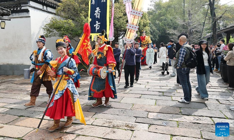 Visitors watch a folk parade during a folk fair in Wuzhen, Tongxiang City, east China's Zhejiang Province, April 1, 2026. A folk fair opened here on Wednesday, during which people can experience the atmosphere of traditional sericulture and enjoy the spring scenery through folk parades both on the street and on the water. (Xinhua/Xu Yu)

