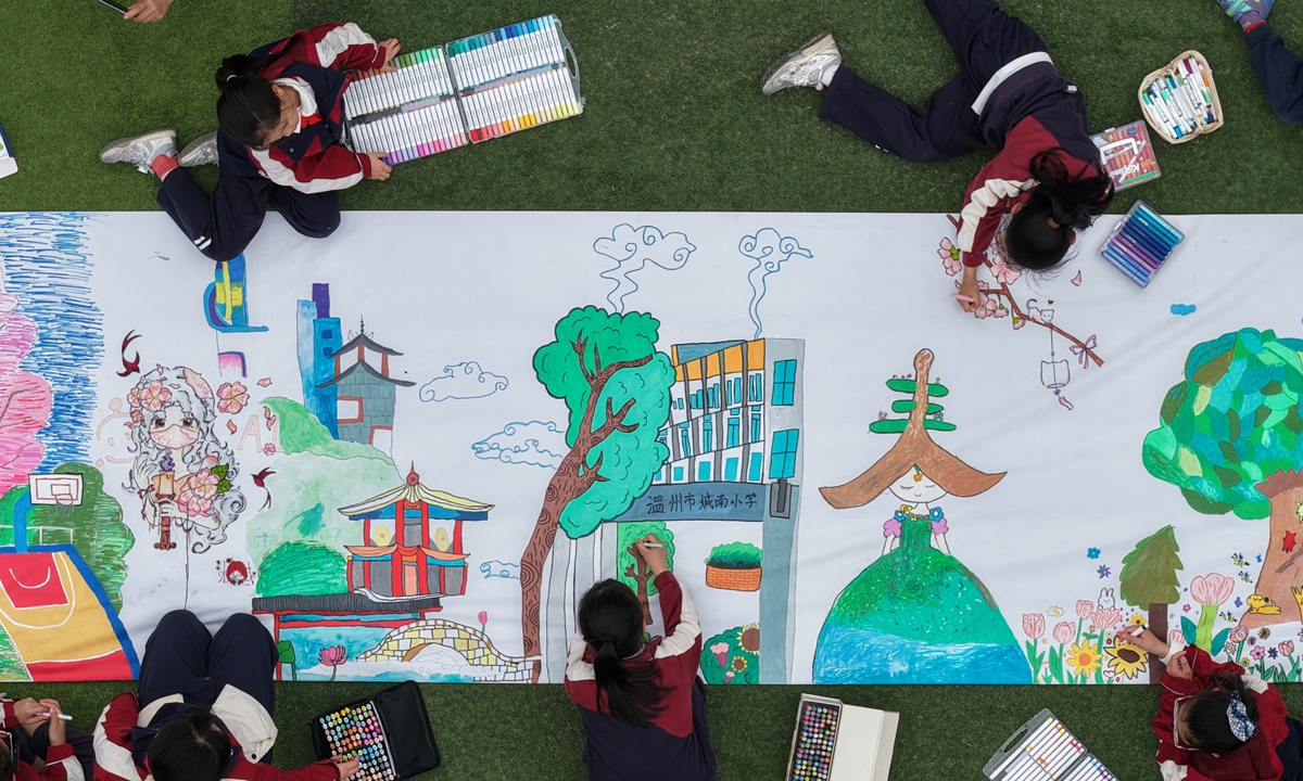 Students from a primary school in Wenzhou, East China's Zhejiang Province, sketch their ideal visions of spring on a 30?meter canvas using colored markers on April 2, 2026. Photo: VCG