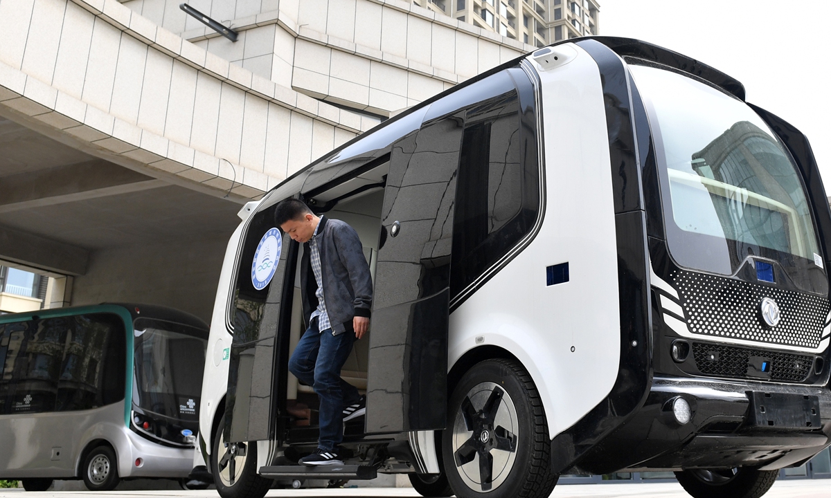 A staff member conducts a test ride on an autonomous bus at a science and technology park in Xiong'an on April 26, 2021. Photo: VCG