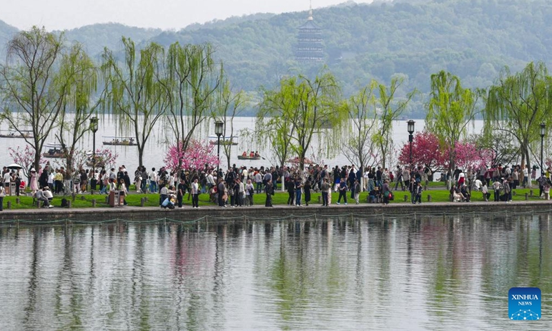 Tourists visit the West Lake scenic area in Hangzhou, east China's Zhejiang Province, April 2, 2026. Recently, West Lake in Hangzhou has been adorned with blooming peach trees and verdant willows, showing bright spring colors that attract crowds of visitors. (Xinhua/Huang Zongzhi)