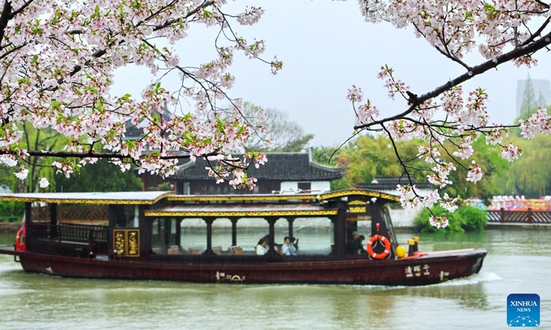 Tourists take a boat for sightseeing amid rain at a scenic area in Jiaxing City, east China's Zhejiang Province, April 3, 2026. (Photo by Jin Peng/Xinhua)