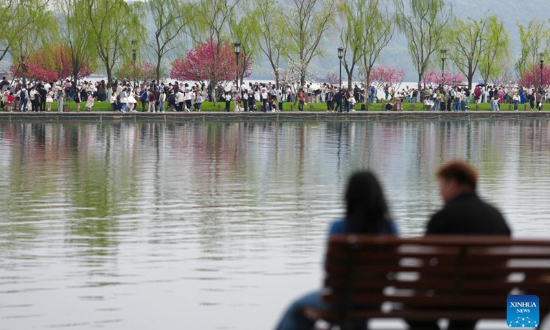 Tourists visit the West Lake scenic area in Hangzhou, east China's Zhejiang Province, April 2, 2026. Recently, West Lake in Hangzhou has been adorned with blooming peach trees and verdant willows, showing bright spring colors that attract crowds of visitors. (Xinhua/Huang Zongzhi)