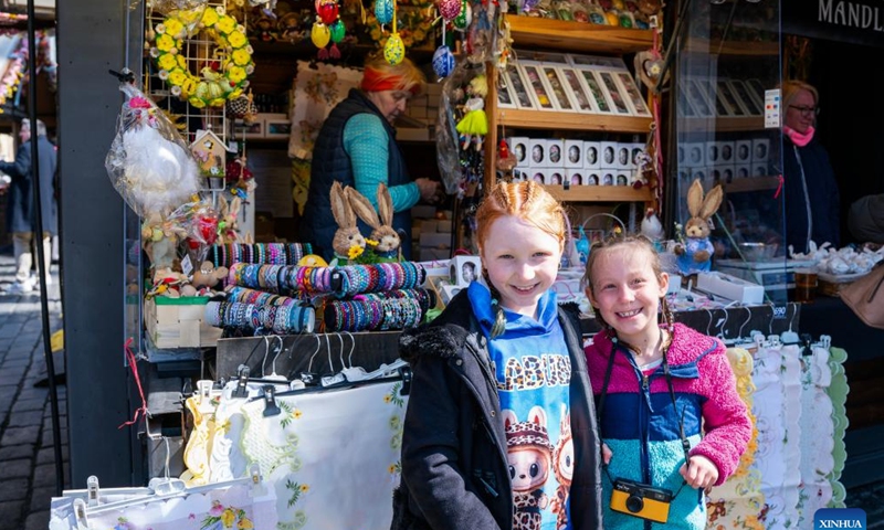 Girls pose at an Easter market in Prague, the Czech Republic, April 2, 2026. As Easter approaches, a market is held in Prague's old city, attracting residents and tourists to experience the festive atmosphere. (Photo by Dana Kesnerova/Xinhua)