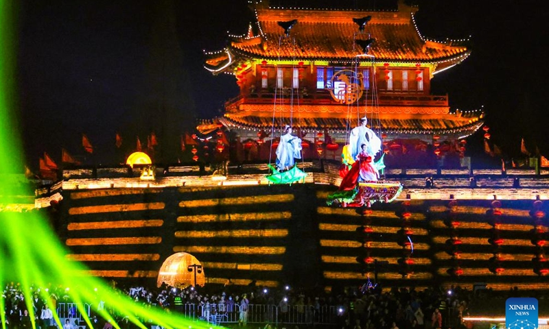 A performance is staged outside the Jingzhou ancient city in Jingzhou, central China's Hubei Province, April 3, 2026. The performance aiming at boosting spring cultural tourism was staged here on the evening of Friday, attracting lots of visitors. (Photo by Xiao Qi/Xinhua)