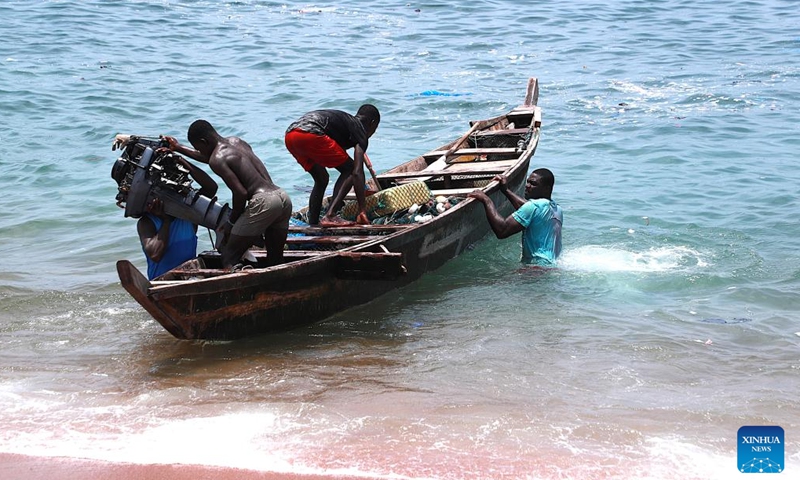 Fishermen load engines onto fishing boats in Abidjan, Cote d'Ivoire, April 3, 2026. Along the coastline of Abidjan, fishing is closely intertwined with local community life. (Photo by Yvan Sonh/Xinhua)