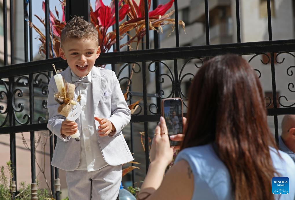 A boy poses for photos in celebration of Palm Sunday in Beirut, Lebanon, April 5, 2026. Palm Sunday, a Christian feast that falls on the Sunday before Easter, marks the beginning of the Holy Week. (Photo by Bilal Jawich/Xinhua)