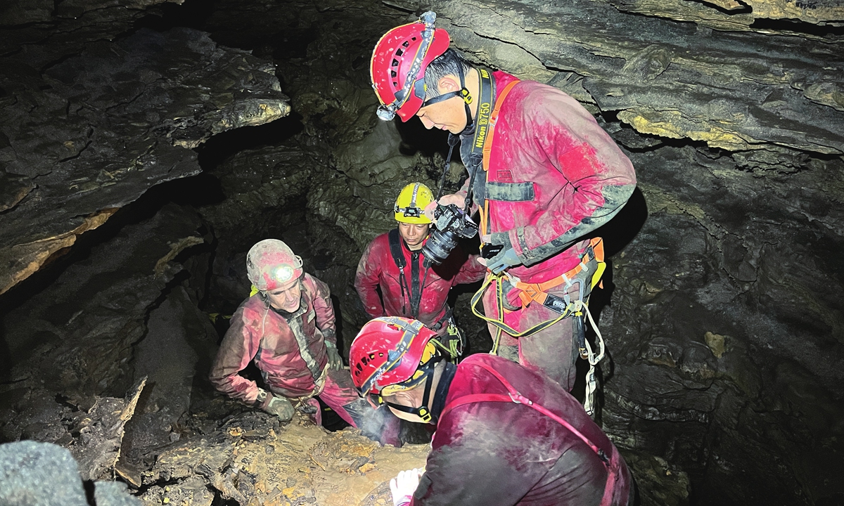 Experts inspect fossil remains in the Shuanghe Cave in 2022. 