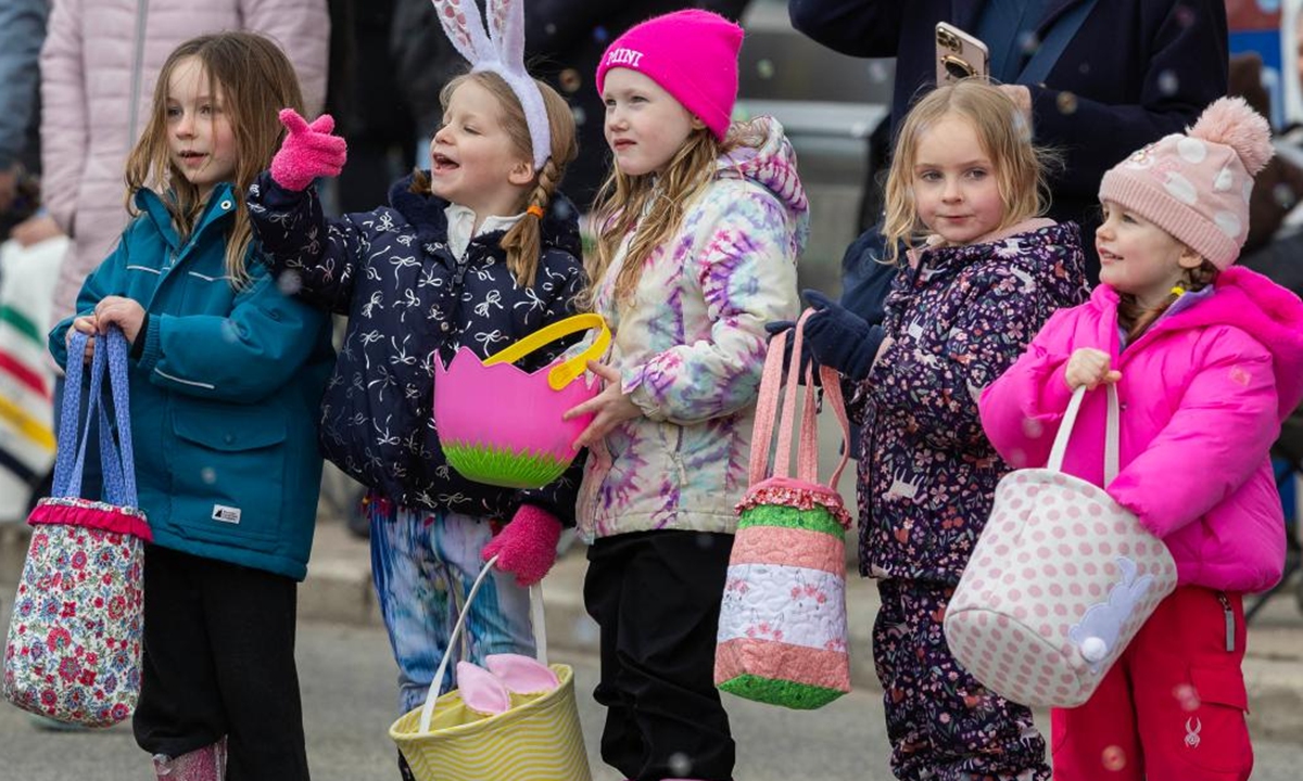 Children wait for candy distribution during the 2026 Toronto Beaches Lions Easter Parade in Toronto, Canada, on April 5, 2026. (Photo by Zou Zheng/Xinhua)