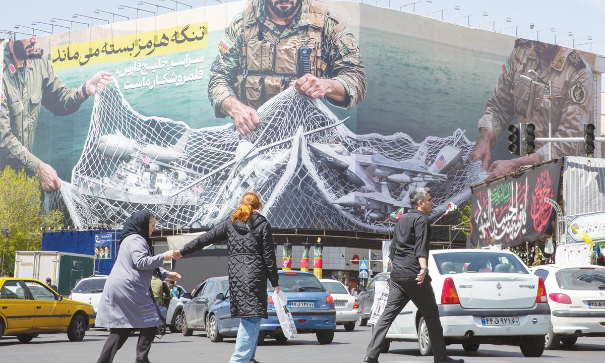 On April 5, 2026, a new billboard in Enghelab square in Tehran, Iran, shows Iranian military commanders capturing US aircrafts in a net with a message saying The Strait of Hormuz will stay closed. Photo: VCG