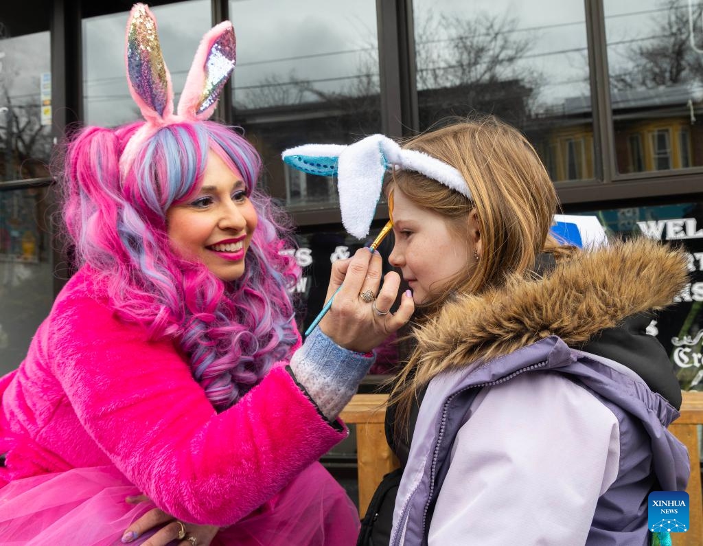 A girl participates in a face-painting activity during the 2026 Toronto Beaches Lions Easter Parade in Toronto, Canada, on April 5, 2026. (Photo by Zou Zheng/Xinhua)
