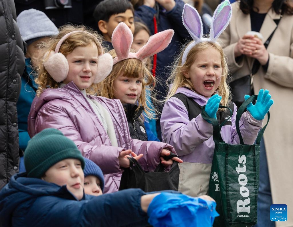 Children wait for candy distribution during the 2026 Toronto Beaches Lions Easter Parade in Toronto, Canada, on April 5, 2026. (Photo by Zou Zheng/Xinhua)