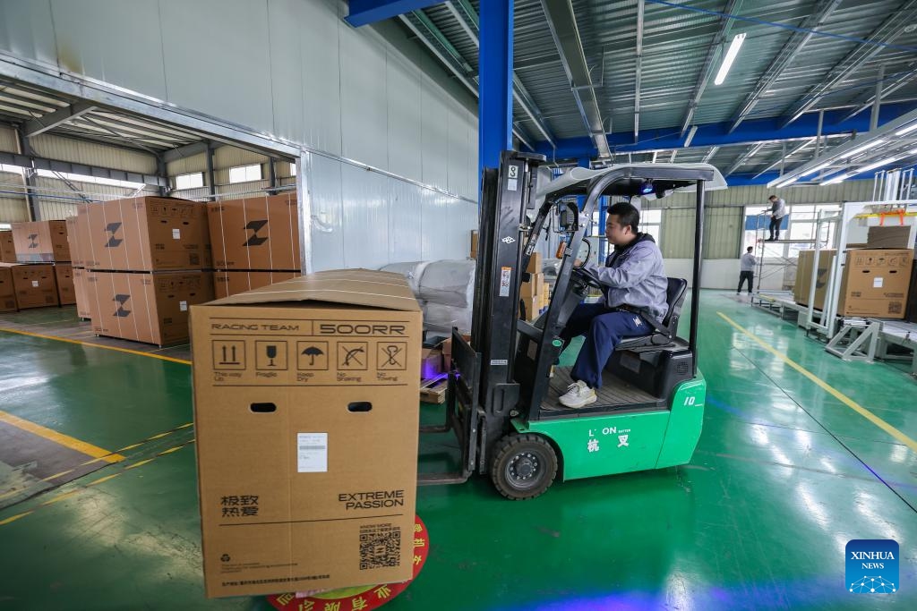 An employee transports motorcycles to be shipped at ZXMOTO in Liangjiang New Area, southwest China's Chongqing, on April 1, 2026. (Xinhua/Huang Wei)