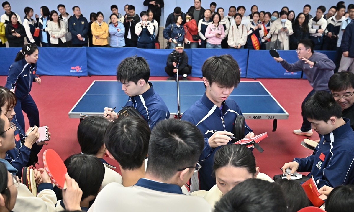 National team athletes Huang Youzheng (center, left) and Sun Yang (center, right) sign autographs for students at the High School Affiliated to Shanxi University in Taiyuan, North China's Shanxi Province, on April 7, 2026 as part of the 