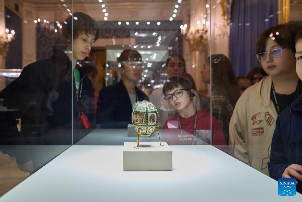 Visitors view the Fifteenth Anniversary Easter Egg at Fabergé Museum in St. Petersburg, Russia, on April 7, 2026. The Fabergé Museum boasts a collection of over 4,000 works of art, including gold and silver objects as well as porcelain. Among its most celebrated treasures is a set of nine imperial Easter eggs. (Photo by Guo Feizhou/Xinhua)