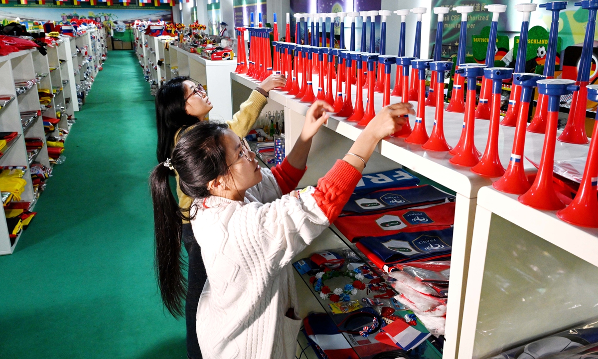 Two workers sort samples of fan products manufactured for participating national teams of the 2026 World Cup in a company in Wuyi county of East China's Zhejiang Province on April 8, 2026. The company has secured a large number of orders for national flags, scarves, capes, hats, backpacks, and other fan merchandise from countries such as Brazil, Argentina, and Canada. Photo: VCG