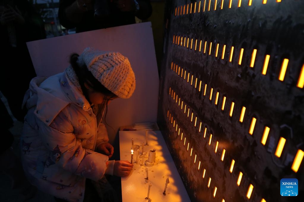 A girl lights a candle during a memorial event held to mourn the students of an elementary school who were killed in a missile strike in southern Iran, in Tehran, Iran, April 6, 2026. A missile strike on an elementary school in Minab, southern Iran on Feb. 28, 2026 killed at least 175 people, most of them schoolgirls. Increasing evidence has shown this tragedy was of the U.S. making. (Xinhua/Shadati)