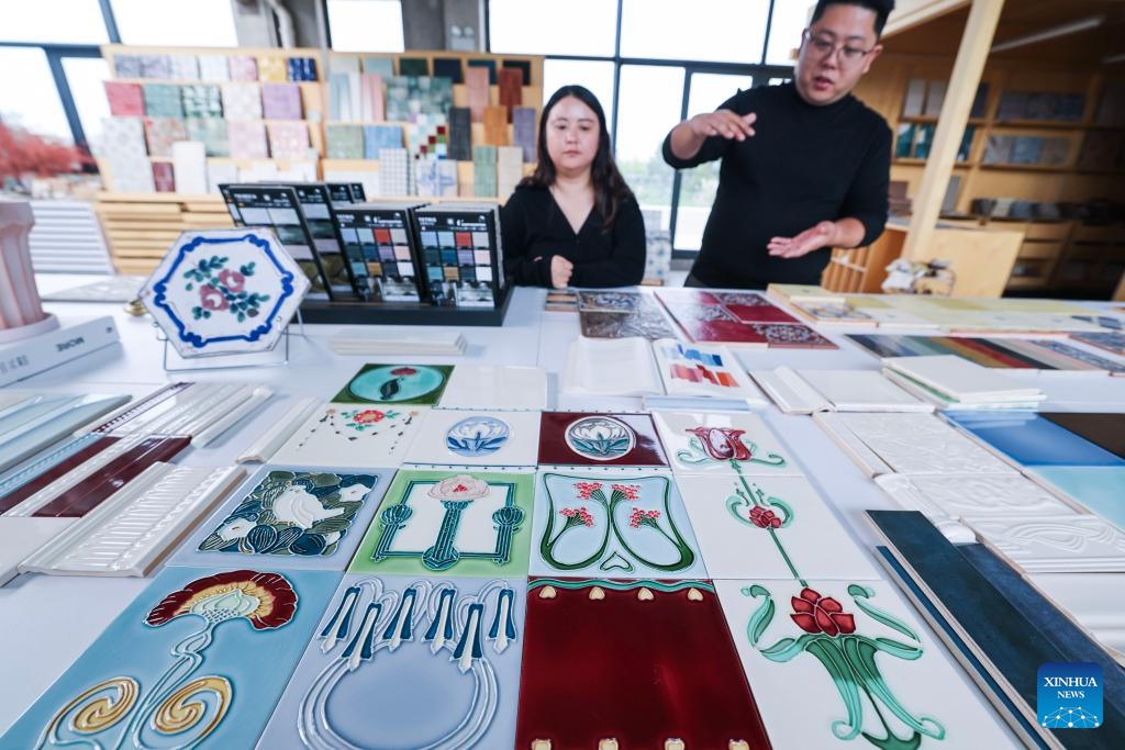 Zhu Xiaodong (R) introduces design concept of tiles at a workshop in Yuxin Town, Nanhu District of Jiaxing City, east China's Zhejiang Province, April 8, 2026.(Xinhua/Xu Yu)