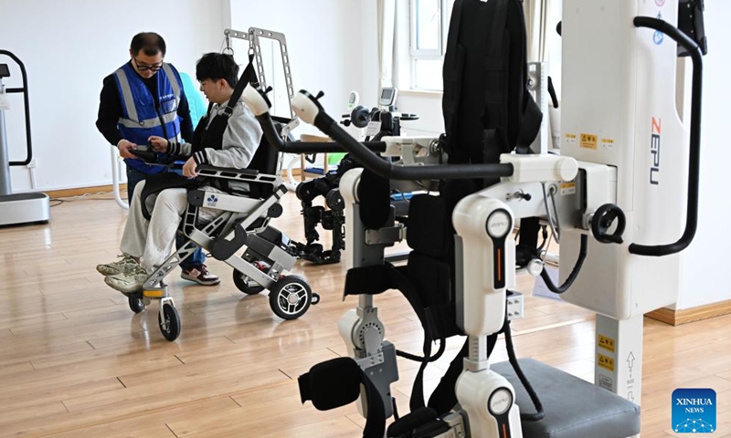 Staff members test a walking assistance robot at Qingdao Training Center for Elderly Care Robots in Qingdao, east China's Shandong Province, April 9, 2026.(Xinhua/Li Ziheng)


