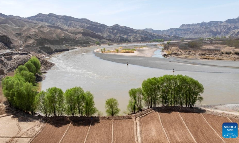 An aerial drone photo taken on April 6, 2026 shows trees turning green in Nanchangtan Village of Zhongwei City, northwest China's Ningxia Hui Autonomous Region. Nanchangtan nestles in a crescent-shaped riverbank area, where the Yellow River, China's second-longest river, flows through when entering Ningxia. (Xinhua/Wang Peng)