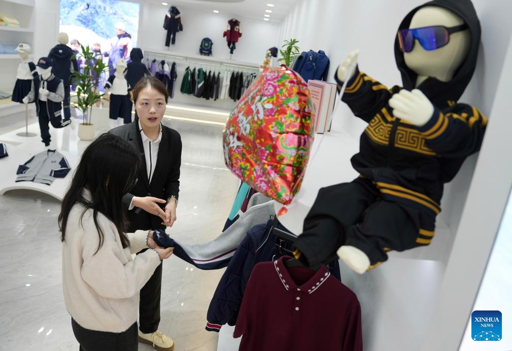 A staff member introduces products to a client at a children's clothing company in Zhili Town, Huzhou City of east China's Zhejiang Province, April 13, 2026. 