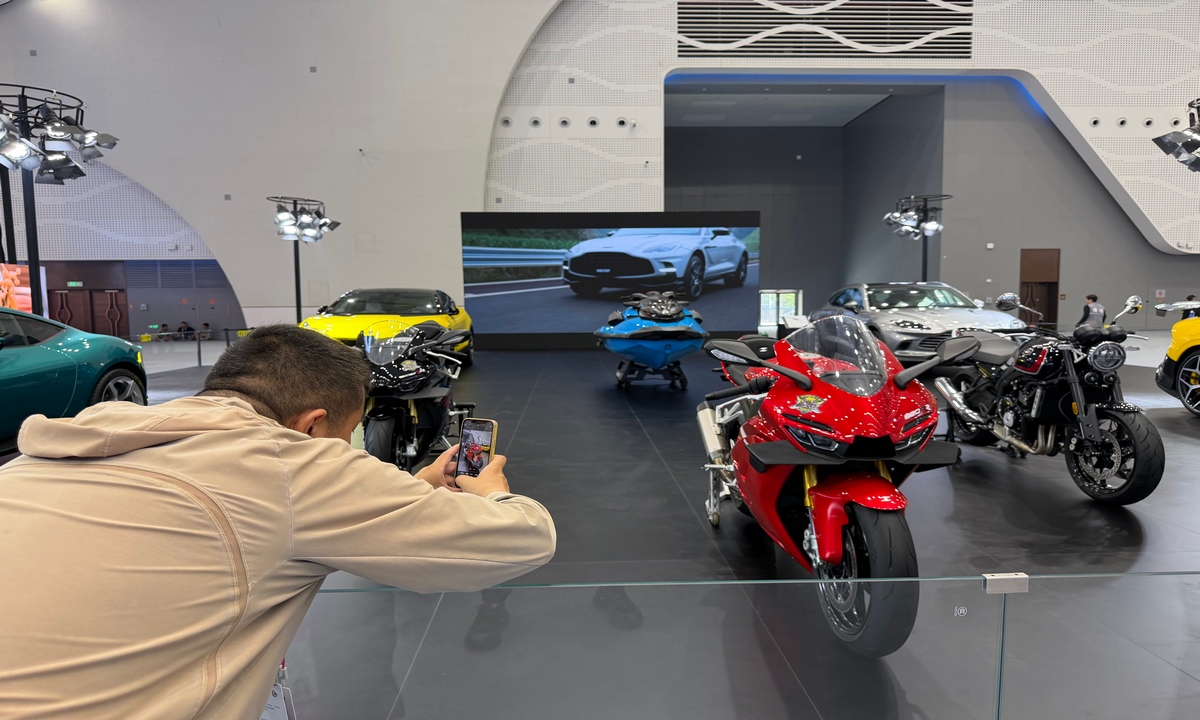 A visitor takes a photo of the red 820RR model, made by ZXMOTO, displayed at center stage at a booth at this year's China International Consumer Products Expo in Haikou, South China's Hainan Province, on April 14, 2026. Photo: Tu Lei/GT
