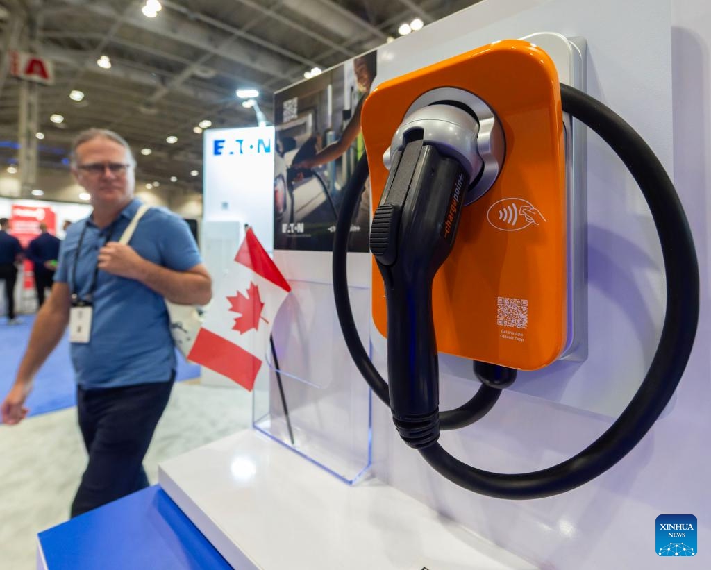 A man views an electric vehicle (EV) charging device during the EV & Charging Expo 2026 in Toronto, Canada, on April 8, 2026. Exploring electric vehicles and charging solutions for fleets, buildings and commercial sites, the two-day event kicked off here on Wednesday, with about 2,000 attendees from more than 800 organizations. (Photo by Zou Zheng/Xinhua)

