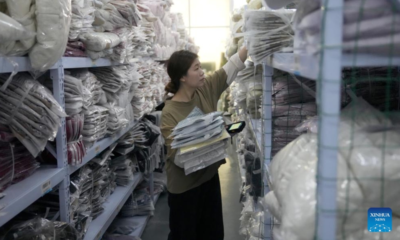 A staff member prepares products for orders at a store of a children's clothing company in Zhili Town, Huzhou City of east China's Zhejiang Province, April 13, 2026. 