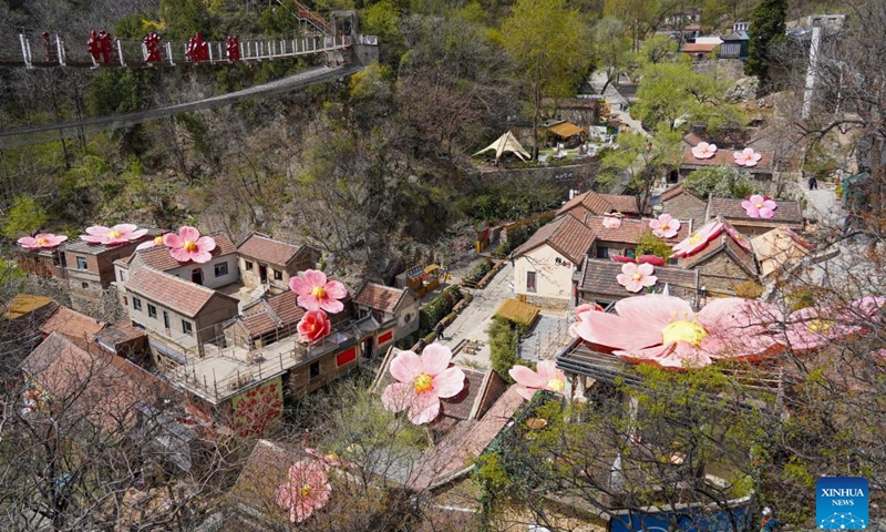 People visit the Hongye Shiyan scenic spot in Zibo City, east China's Shandong Province, April 8, 2026. The scenic spot has increased the income of nearby villagers by creating an immersive scene of flowering sightseeing. (Xinhua/Zhu Zheng)

