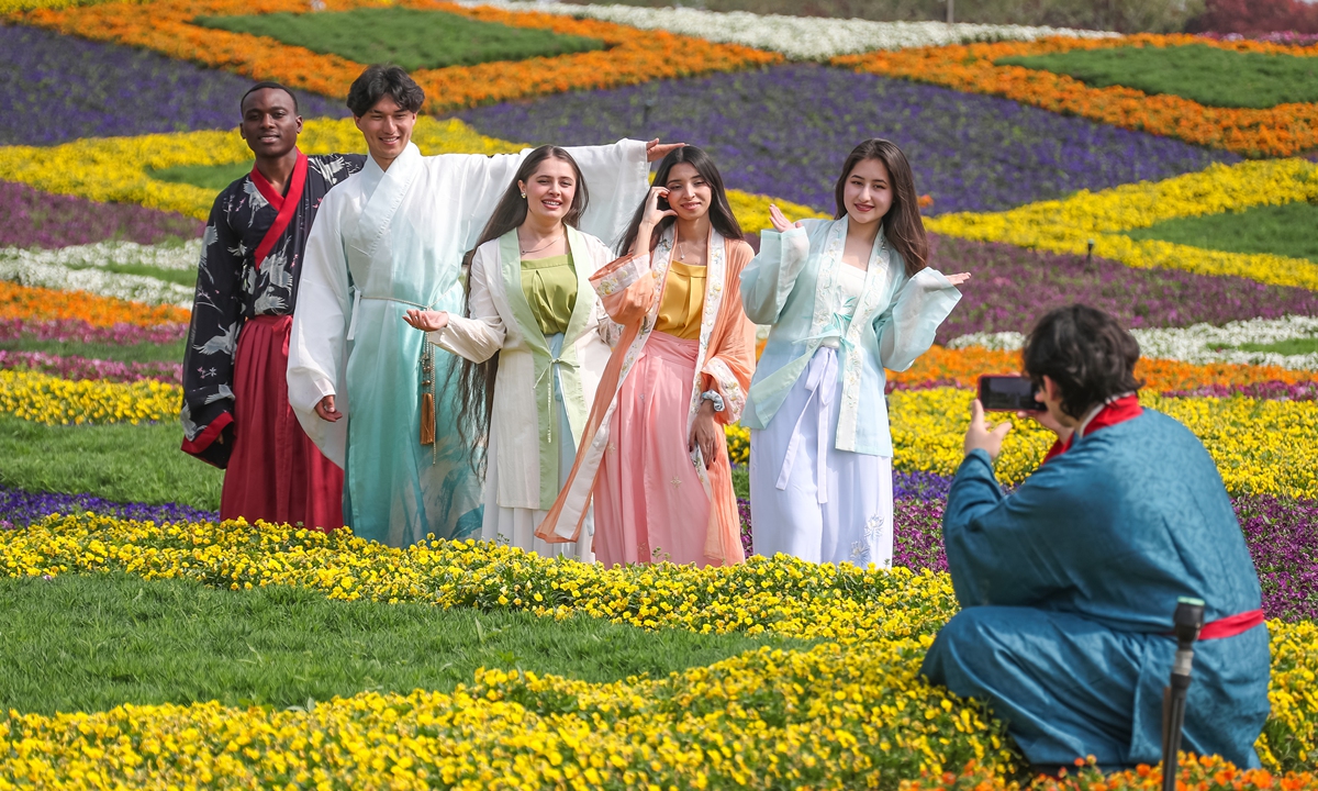 Foreign students pose for photos among blooming flower fields in Jurong, East China's Jiangsu Province on April 10, 2026.