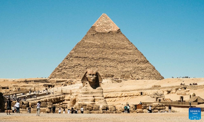 Tourists visit the Sphinx in the Giza Pyramids scenic spot in Giza, Egypt, April 9, 2026. The Giza Pyramids located southwest of Cairo, capital of Egypt, are one of the most representative sites of ancient Egyptian civilization. The complex includes the three pyramids known as the Great Pyramids, the massive sculpture known as the Great Sphinx, and several ancient cemeteries and smaller pyramids. The pyramids are part of a UNESCO World Heritage Site inscribed in 1979. (Xinhua/Xin Mengchen)