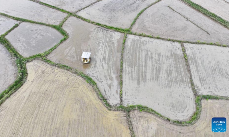 An aerial drone photo taken on April 8, 2026 shows an agricultural machine working in early-season rice fields in Yongzhou, central China's Hunan Province. (Photo by He Hongfu/Xinhua)

