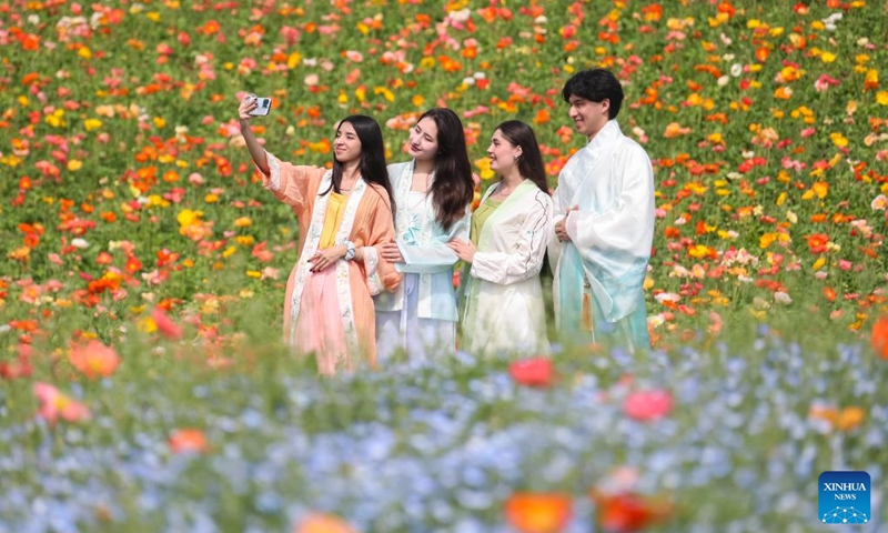 Foreign students take selfies with flowers in Baitu Town of Jurong, east China's Jiangsu Province, April 10, 2026. (Photo by Zhong Xueman/Xinhua)