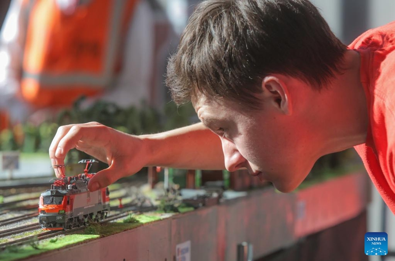 A designer arranges exhibits during an exhibition of train and railway dioramas in St. Petersburg, Russia, on April 11, 2026. The exhibition kicked off here on Saturday, showcasing over 240 train and railway dioramas from Russia and other countries. The event runs until April 19. (Photo by Irina Motina/Xinhua)