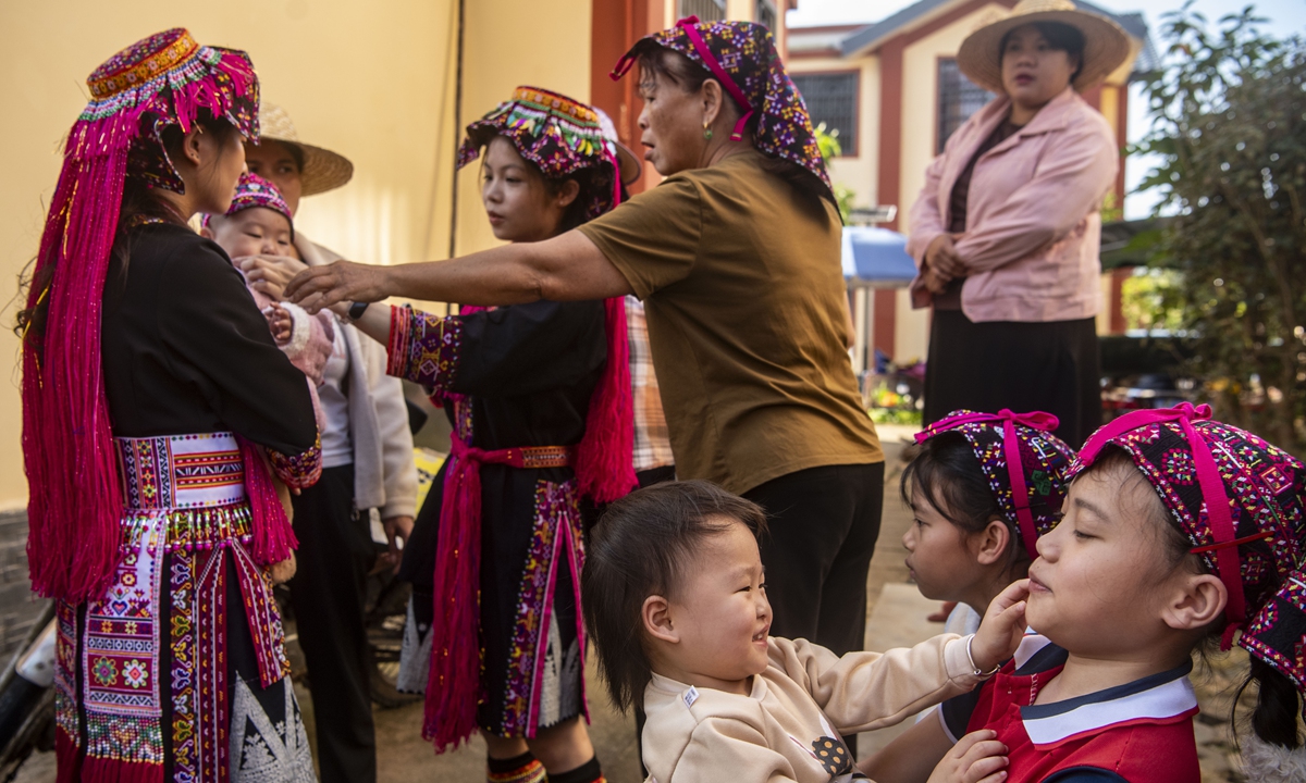 Relocated villagers play with children at the village entrance in Qionghai, South China's Hainan Province, on February 11, 2026.