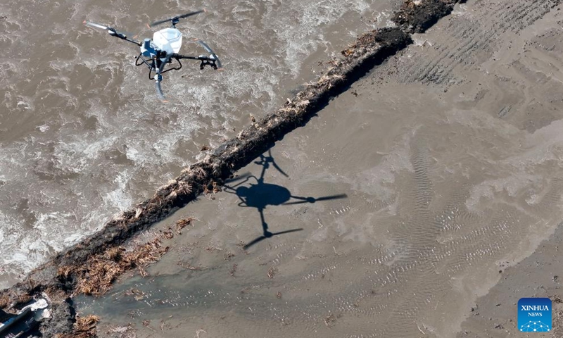 A drone photo taken on April 9, 2026 shows an agricultural drone spraying fertilizer onto a paddy field of Youyi Farm Co., Ltd. under Beidahuang Group in Shuangyashan, northeast China's Heilongjiang Province. Heilongjiang, a major grain-producing area in China, has entered the spring ploughing season for rice. (Xinhua/Wang Song)