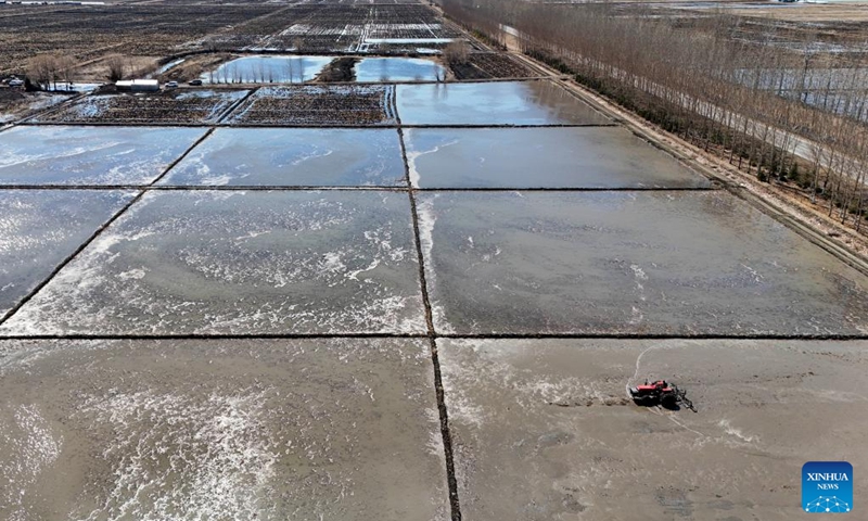 An aerial drone photo taken on April 9, 2026 shows a farming machine ploughing a paddy field of Youyi Farm Co., Ltd. under Beidahuang Group in Shuangyashan, northeast China's Heilongjiang Province. Heilongjiang, a major grain-producing area in China, has entered the spring ploughing season for rice. (Xinhua/Wang Song)