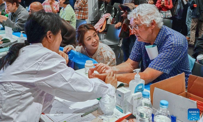 Visitors try free clinic service at the Chinese + TCM South Island Roadshow in Christchurch, New Zealand, April 11, 2026. The Chinese + TCM (traditional Chinese medicine) South Island Roadshow was held here on Saturday. A team from Zhejiang Chinese Medical University engaged local audiences with lectures, interactive demonstrations and hands-on activities during the event. (Photo by Chen Siyumeng/Xinhua)