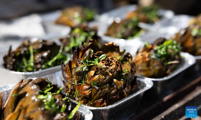 Artichoke snacks are displayed during a Roman artichoke festival in Ladispoli, Italy, April 10, 2026. The annual festival celebrating the harvest of the Roman artichoke kicked off on Friday. (Xinhua/Li Jing)