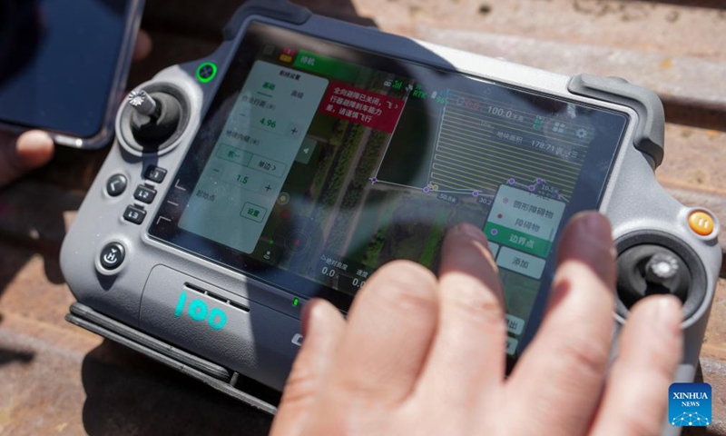 A farmer operates an agricultural drone to spray fertilizer onto paddy fields of Youyi Farm Co., Ltd. under Beidahuang Group in Shuangyashan, northeast China's Heilongjiang Province, April 9, 2026. Heilongjiang, a major grain-producing area in China, has entered the spring ploughing season for rice. (Xinhua/Wang Song)