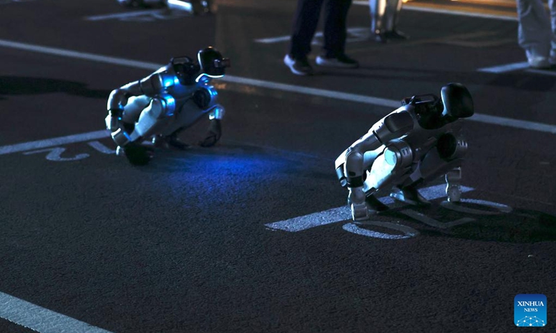 Two humanoid robots are seen before the test activity for the 2026 Beijing E-Town Humanoid Robot Half Marathon on April 11, 2026. A full-process and comprehensive testing activity for the Beijing E-Town humanoid robot half-marathon, scheduled for April 19, 2026, was carried out from Saturday night to early Sunday morning. (Photo by Zhai Yifan/Xinhua)